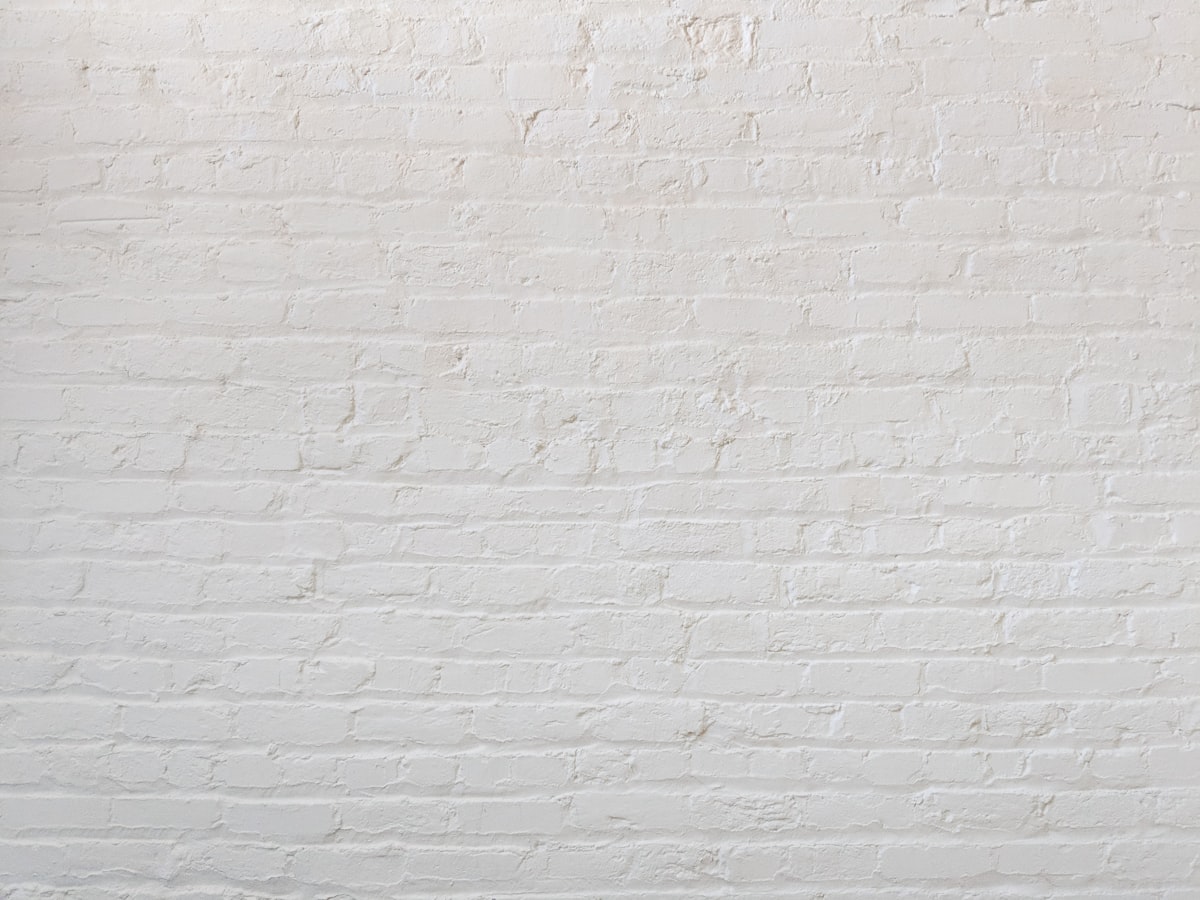 A painted white brick wall in even light, course after course laid to the same line.